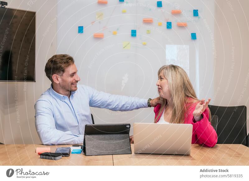 Coworking colleagues collaborating in a modern office coworking collaboration professional discussion friendly laptop sticky note workspace business meeting