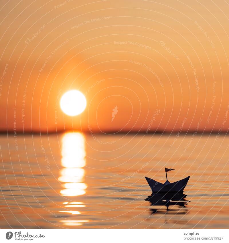 Small paper ship sails into the sunset on a lake in Finland Paper boat Sun Sunset Lake Ocean Water Wellness relax tranquillity Orange be afloat ship flag