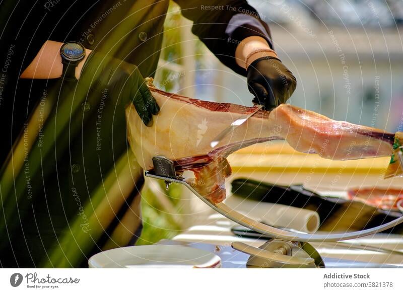 Expert carving at culinary event gourmet food stall spanish cured ham thin slice professional attire expert blade cut serve gastronomy tradition meat specialty