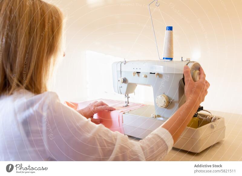 Seamstress Working on Sewing Machine in Bright Workshop seamstress sewing machine workshop fabric stitching textile craftsmanship tailor fashion design thread