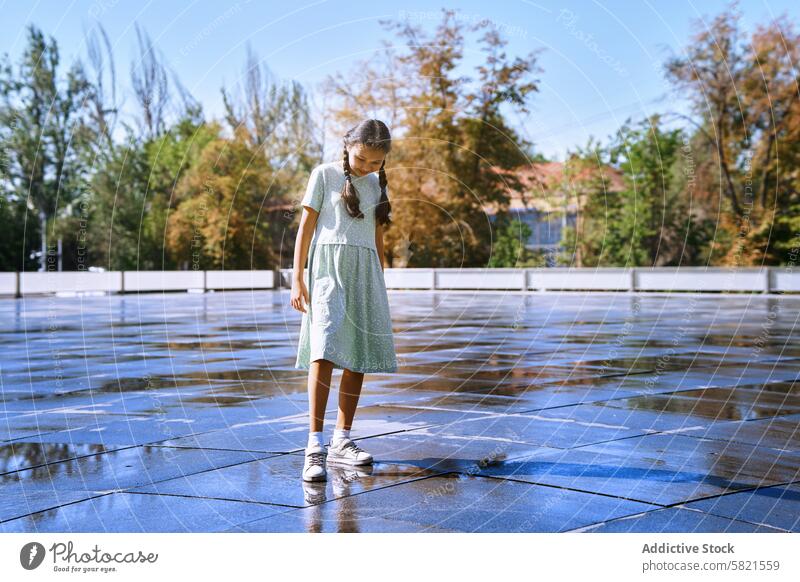 Girl walking in a wet city street after the rain female girl child autism person with autism ADHD neurodiversity autism spectrum childhood kid 10-12 years