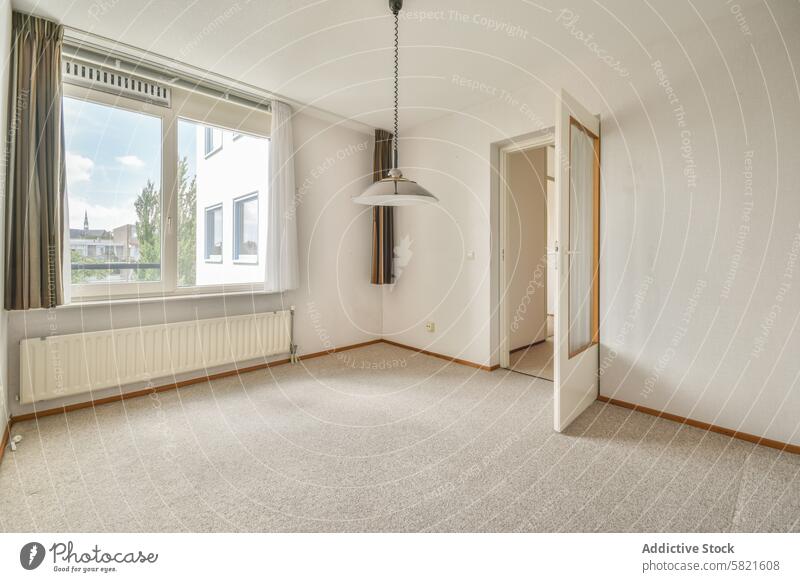 Empty white room with large window and open door light fixture bright spacious empty hanging light carpet interior wall floor estate residential urban
