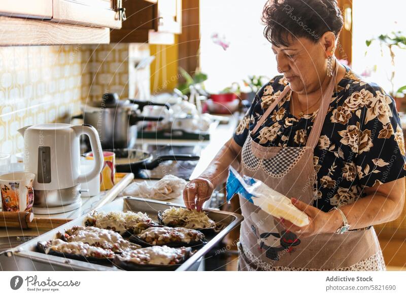 Senior Woman Preparing Meals in a Homely Kitchen senior woman cooking home kitchen food preparation meal elderly baking culinary domestic life cookery apron