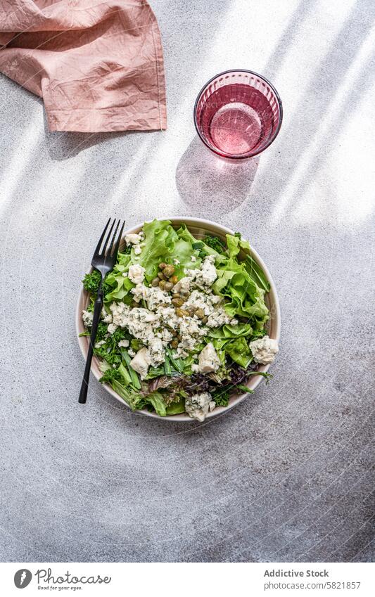 Fresh herb salad with blue brie and capers, with water lettuce green onion parsley tarragon fermented cheese olive oil ceramic bowl glass pure nutrition healthy