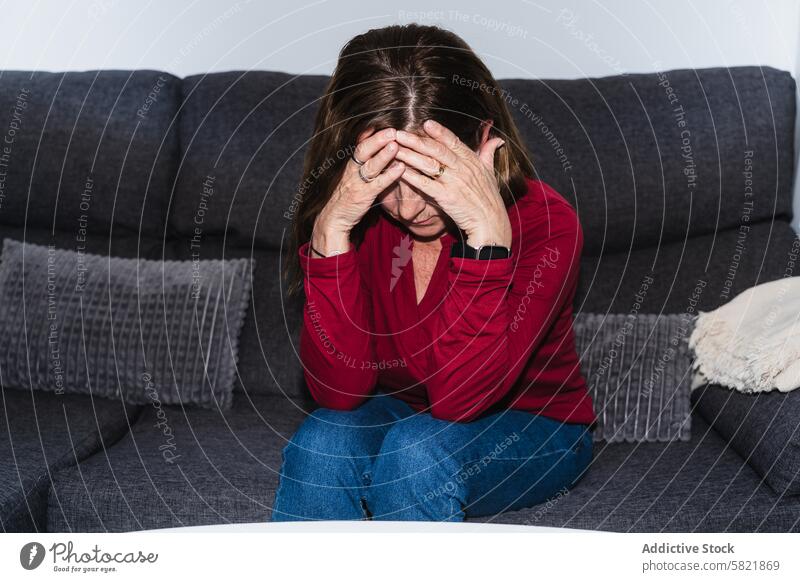 Distressed Woman Experiencing a Hypoglycemia Episode woman distress hypoglycemia health medical episode symptom sofa sitting worried adult discomfort illness