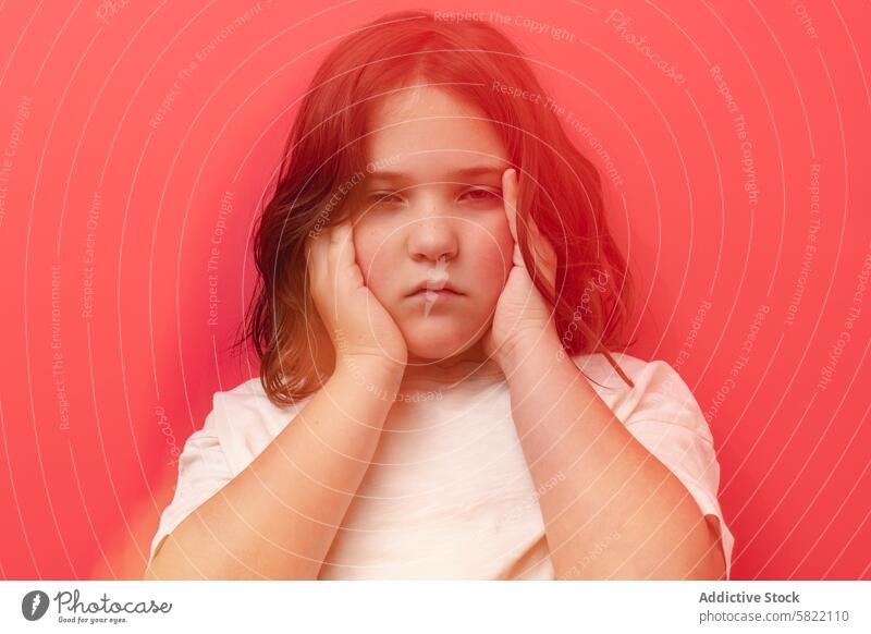 Young girl feeling unwell against a red background discomfort hypoglycemia tired symptom health distress child young female hand face sad medical expression