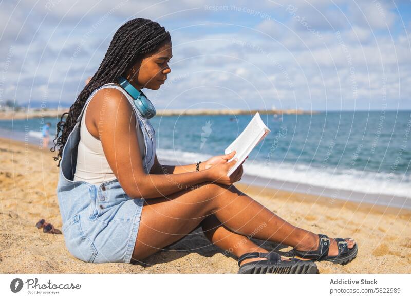 Young Woman Reading Book on Barcelona Beach woman reading book beach barcelona summer sea young solitude sandy leisure relaxation coast waterfront vacation