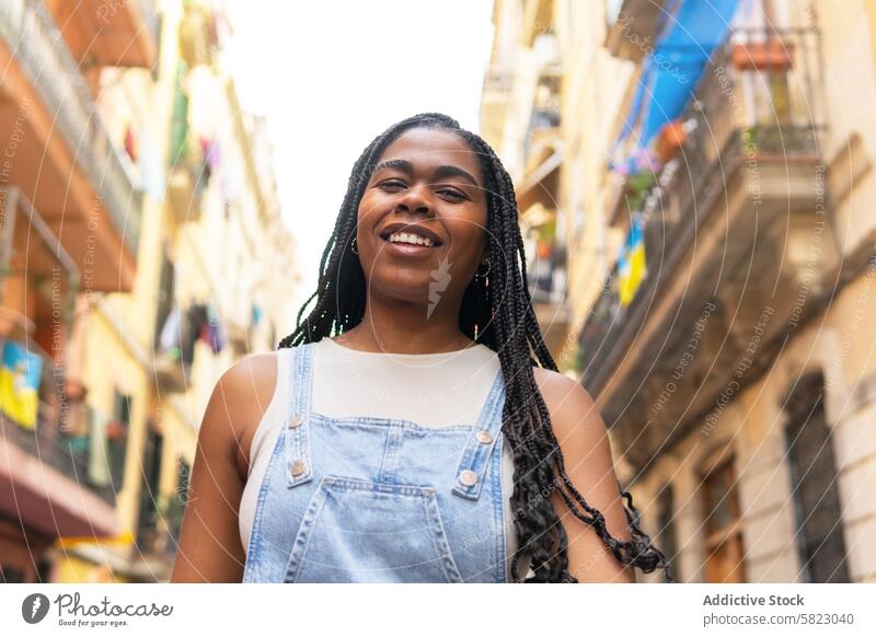 Young woman smiling on a sunny Barcelona street smile barcelona summer travel friendship alley braided hair young cheerful vacation happiness europe spain city
