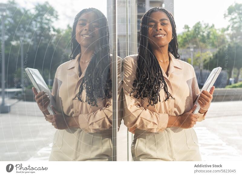 Summer day with a smiling woman holding a tablet in Barcelona summer barcelona reflection glass sunny outdoors modern technology communication fashionable happy