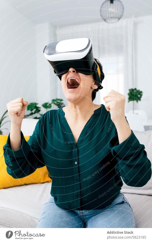 Woman enjoying a virtual reality experience at home woman vr headset technology excitement living room sofa enthusiasm expression adult indoor entertainment