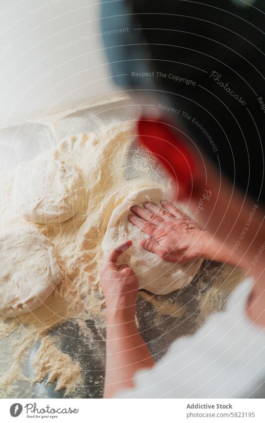 Preparing dough in a pizzeria, close-up and anonymous preparation hand skill worker pizza flour surface dusted faceless kneading bakery craft cuisine making