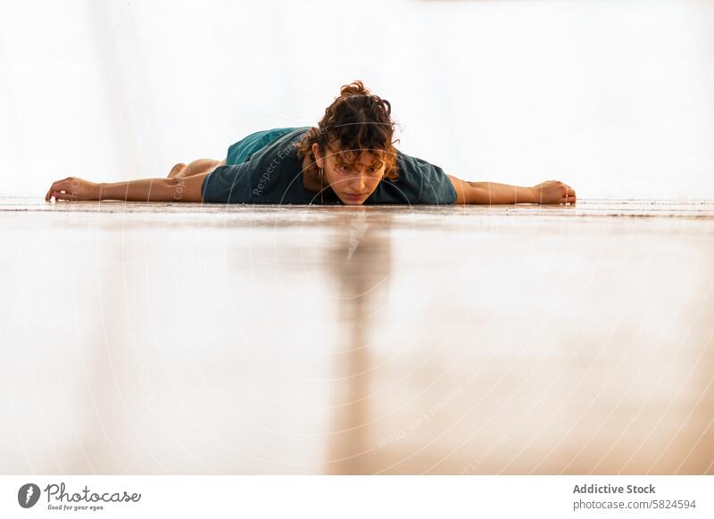 Participant in holistic dance ceremony on studio floor person woman stretch lying serenity focus ceremonial practice movement tranquility mindfulness