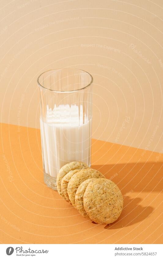 Oatmeal cookies with a glass of milk on a table oatmeal cookies stack crispy snack refreshing beverage dairy orange surface nourishment sweet baked goods