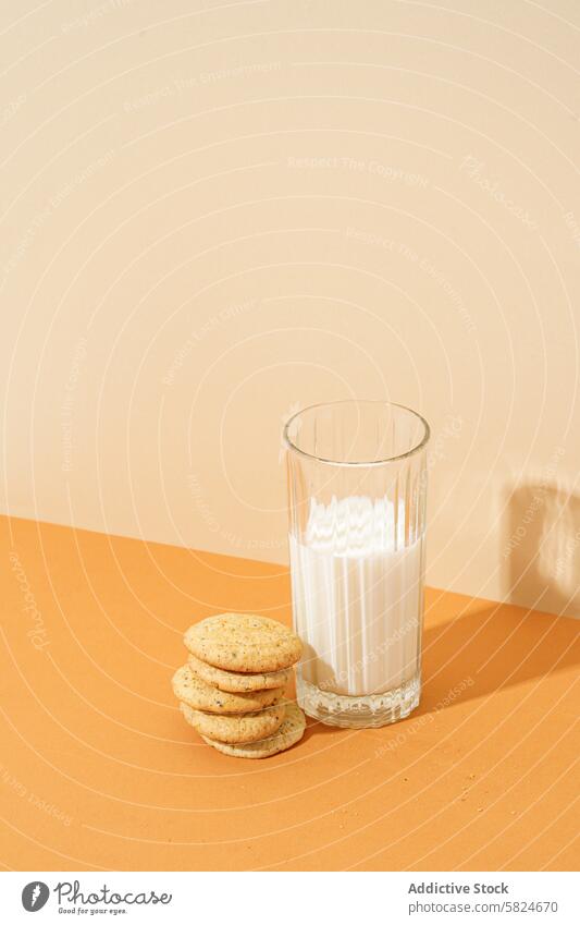 Oatmeal cookies with a glass of milk on a table oatmeal cookies stack crispy snack refreshing beverage dairy orange surface nourishment sweet baked goods