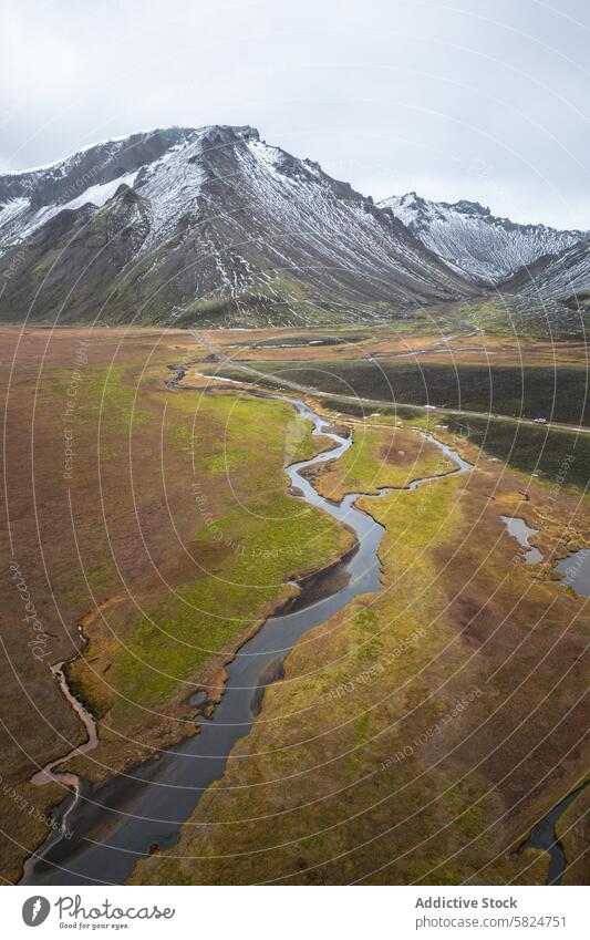 Serene aerial view of a meandering river in highlands landscape tranquil snow-capped mountains serene vast shot nature scenery outdoor wilderness environment