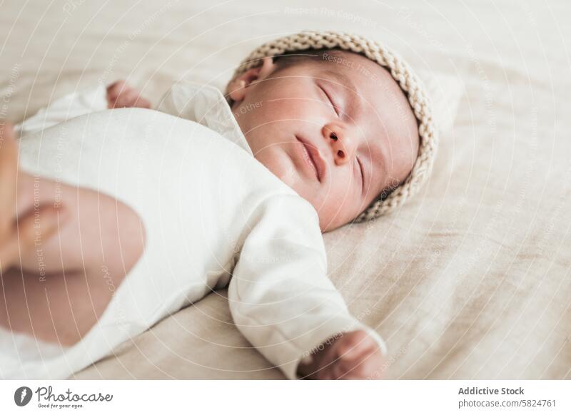 Peaceful newborN sleeping soundly in a knit cap newborn baby infant peaceful serene tranquility innocence blanket soft beige nap rest calm comfortable cute