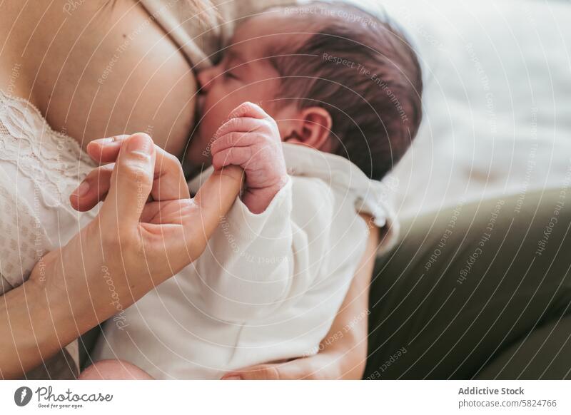 Tender moment between mother and newborn baby breastfeeding intimate bond parent child infant nurture care love maternal close-up lactation tenderness skin