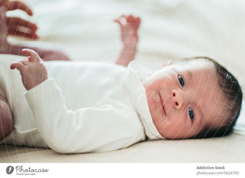 Serene newborn baby lying down in soft lighting infant peaceful serene gentle expression soft surface natural light calm content little young child life