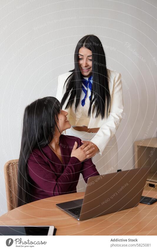 Two professional women collaborating in a home office setting woman collaboration business attire laptop discussion teamwork workplace remote work