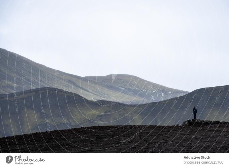 Solitary figure amidst the vast highlands of Iceland iceland solitude person nature landscape outdoors vastness serene isolation grandeur standing mountainous