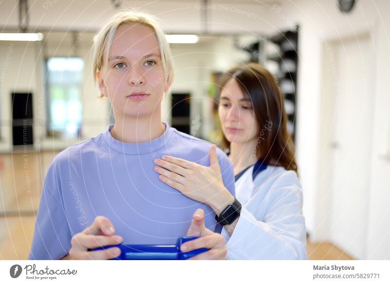 The rehab doctor conducts the patient's appointment in the gym. The PMR specialist trains the patient to perform recovery exercises correctly. physical medicine