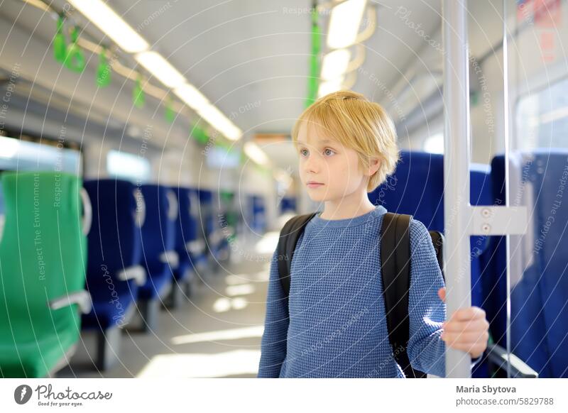 Cute preteen boy in a cabin of subway or local train. Child passenger of comfortable transport of big city. Urban infrastructure. child metro urban suburb ride