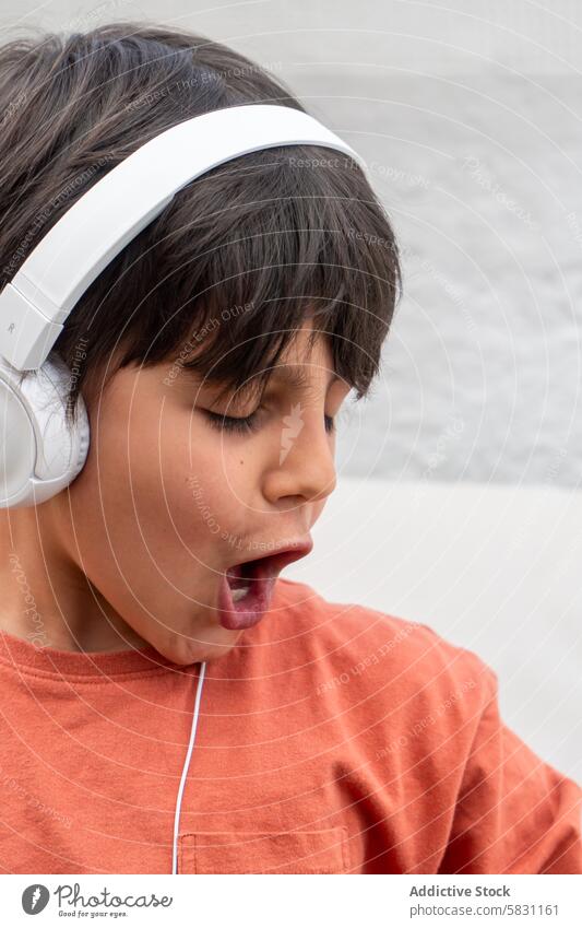 Child blissfully listening to music on Spring weekend boy child listener headphone enjoyment spring grandparent visit leisure youth entertainment sound audio