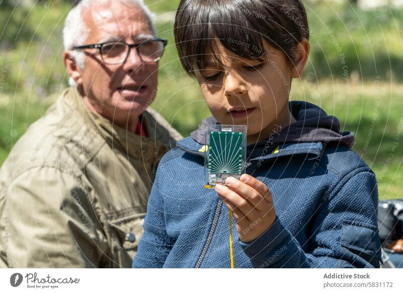 Grandpa and Grandson Exploring with Compass grandfather grandson compass nature spring exploring outdoors adventure learning education family bonding weekend