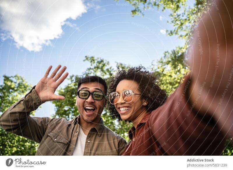 Generated image couple multiethnic chinese hispanic park madrid spain smiling waving selfie outdoors sunny day connection happiness cheerful travel enjoyment