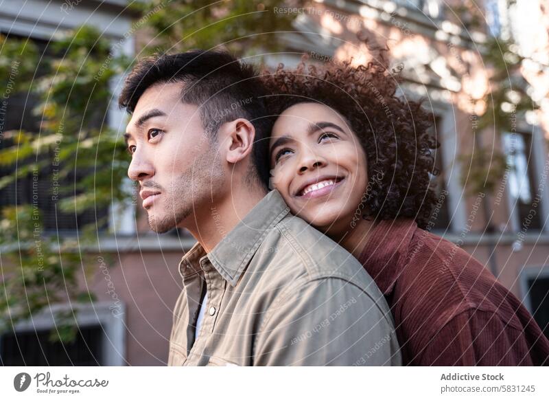 Multiethnic couple enjoying a moment together in vibrant Madrid streets multiethnic chinese hispanic madrid spain love relationship urban diversity happiness