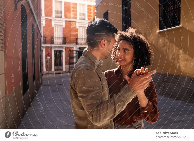 Multicultural couple sharing a moment on picturesque Madrid street multicultural chinese hispanic madrid spain love romantic urban architecture buildings city