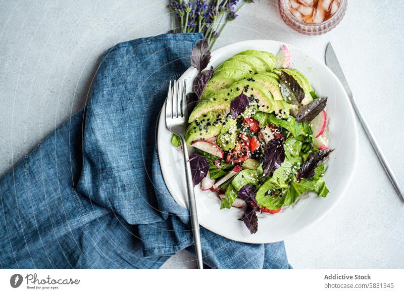 Fresh garden vegetable salad with sesame seeds lettuce olives tomatoes cucumber radish red basil white sesame black sesame bowl colorful fresh healthy meal