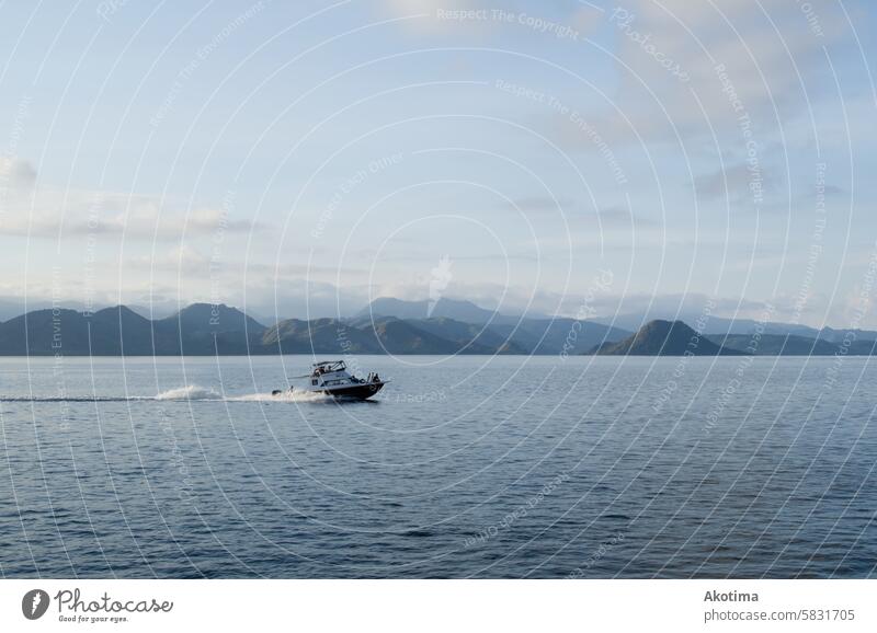 Speedboat in front of mountain range Komodo National Park Travel Indonesia Vacation & Travel Landscape Water Sky Blue sky Clouds Calm watersports Nature Ocean