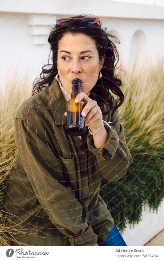 Woman enjoying a beer at the harbor woman drinking port casual relaxed expression bottle sipping leisure adult female outdoors daytime recreation enjoyment