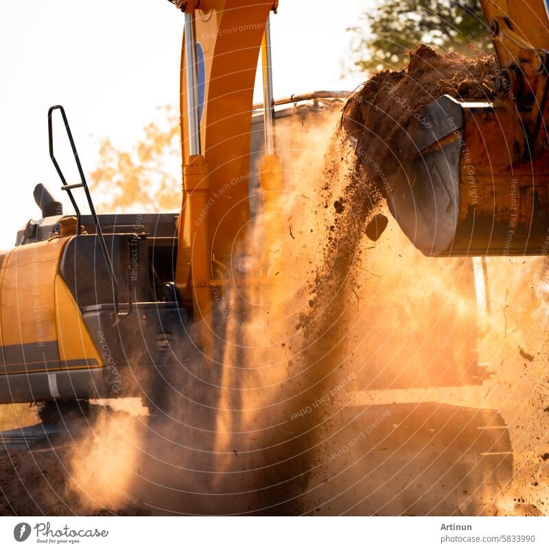 Close-up of excavator at construction site. Backhoe digging soil for earthwork and construction business. Excavating machine at work. Heavy machinery for earth moving and construction site development