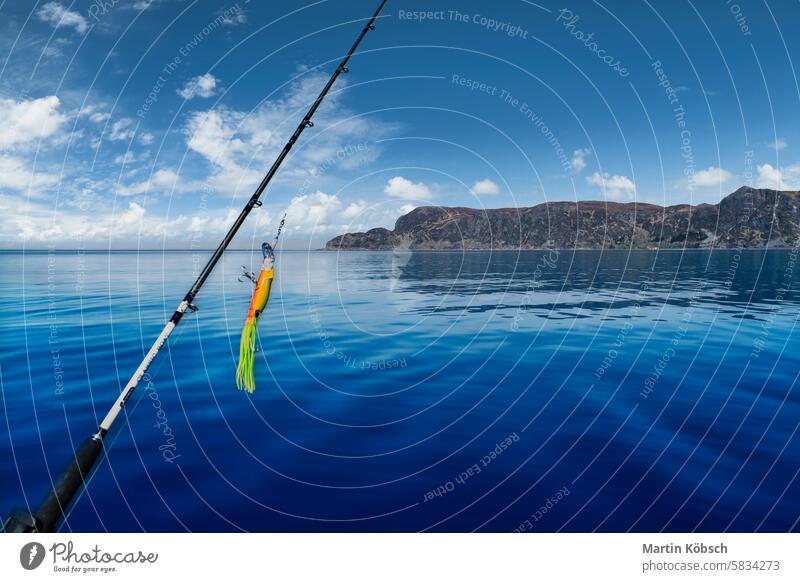 Fishing rod in front of the West Cape in the Norwegian fjord landscape. Scandinavia Fjord fishing holiday sport mountains Norway nature tourism horizontal water