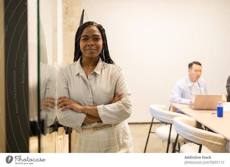 Confident Woman Standing in Collaborative Workspace woman confident standing coworking workspace team office business professional colleague corporate