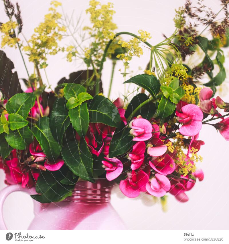 Garden flowers and wild plants together in a jug Chickpea sweet pea Bouquet Water jug garden flowers blossom Summerflower Summer plants Vase with flowers
