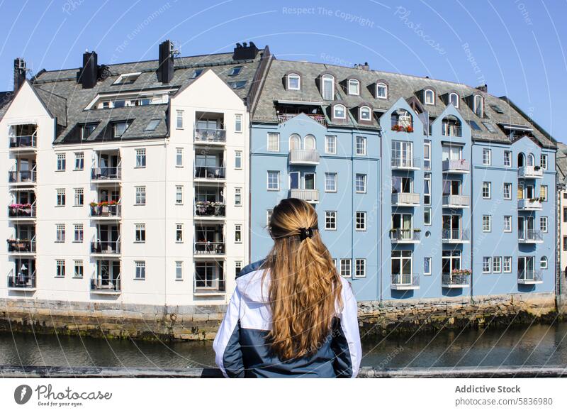 Traveler woman in Alesund city on a sunny summer day, Norway alesund architecture art nouveau attraction back building cityscape coast coastline colourful