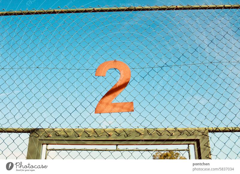 A rusty 2 hangs above the entrance to a tennis court. Tennis Tennis court two number Numbering Sports facility demarcation Ball sports Leisure and hobbies Goal