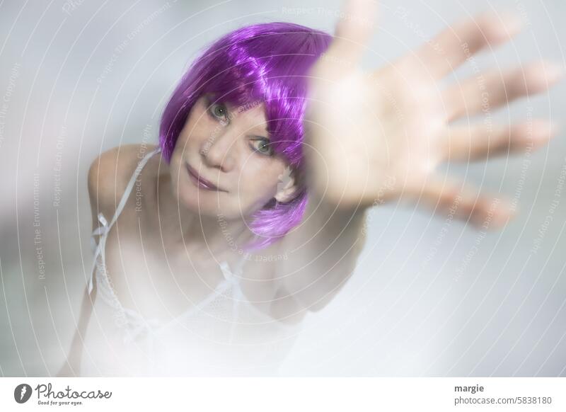 A feminine woman with purple hair waves in a friendly manner Woman portrait Feminine Human being Face Adults Interior shot Hand Wave Hazy Head eyes Shirt