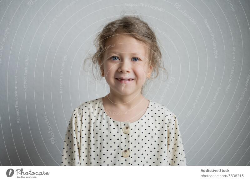 Young girl in polka dot dress smiling at the camera young portrait smile child plain background standing gentle fashion innocence joyful kid female youth happy