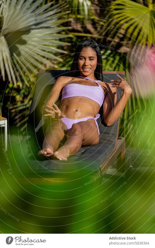 Relaxing Latin Woman in Bikini Enjoying Tropical Sun woman latin bikini sunbed tropical smile looking away relaxation leisure vacation summer tan sunbathing