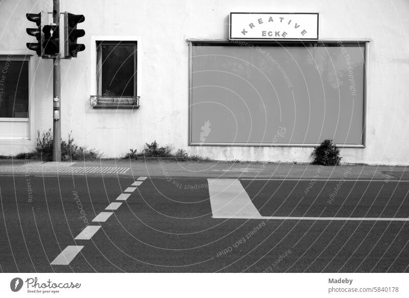 Creative corner with taped-up shop window and crosswalk in the district of Pivitsheide in the province near Lage and Detmold in the Teutoburg Forest in East Westphalia-Lippe in neo-realistic black and white