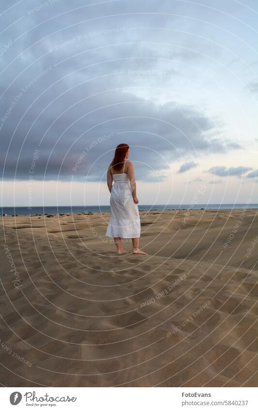 Young woman stands with her back in the sand dunes portrait freckles cute dress European day standing sea female attractive beach sandy beach outdoors