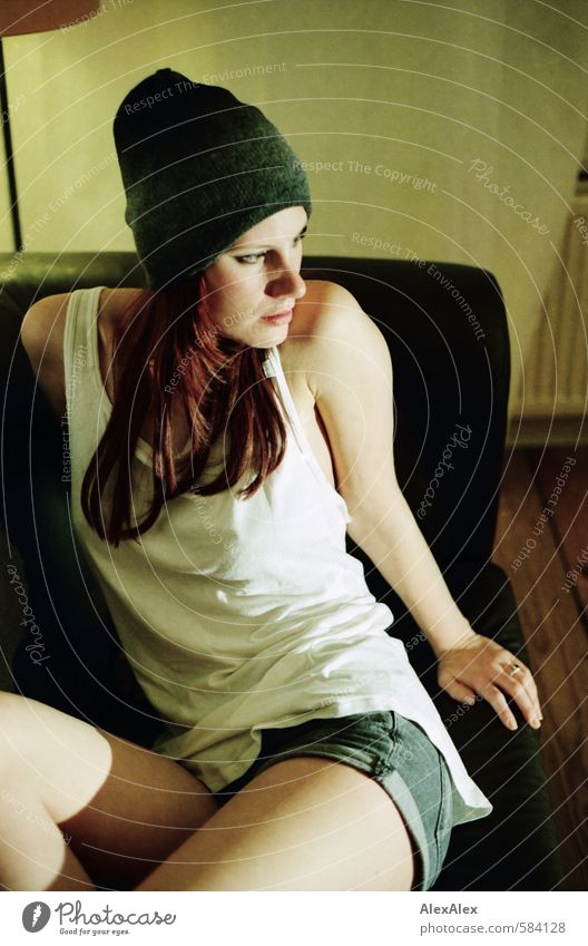 page change Young woman Youth (Young adults) 18 - 30 years Adults Shirt Cap Hot pants Red-haired Long-haired Sofa Observe Sit Esthetic Athletic Exceptional