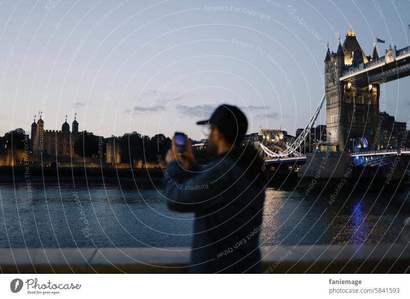 Tourist in London taking a photo of the Tower of London Tourismus Foto Fotos machen Spaziergang Nacht nachts abends Kappe basecap England Großbritannien UK