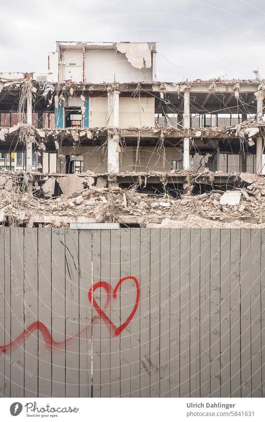 scattered red heart on a gray construction fence with a demolition building in the background Construction site outline Heart Longing graffiti melancholy