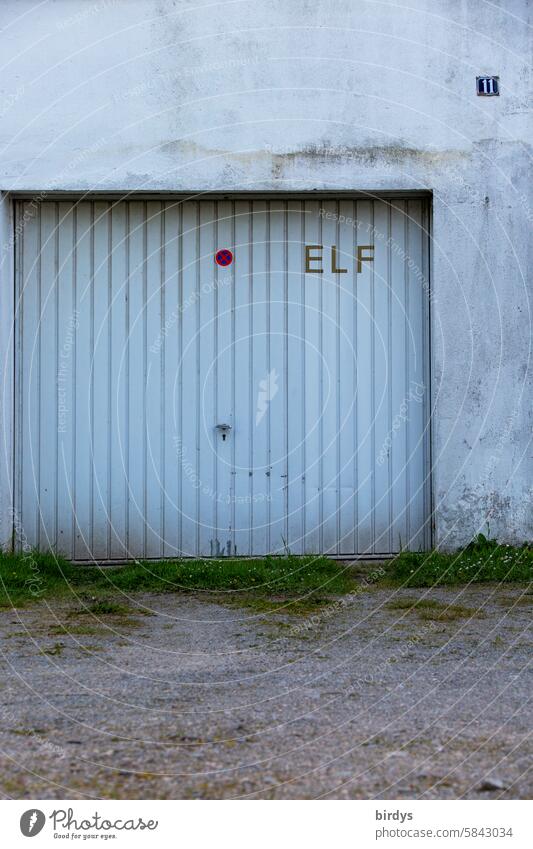 Garage door with the number 11 Old eleven House number Characters digit Highway ramp (entrance) Closed Gloomy metal gate Signs and labeling Building Gravel