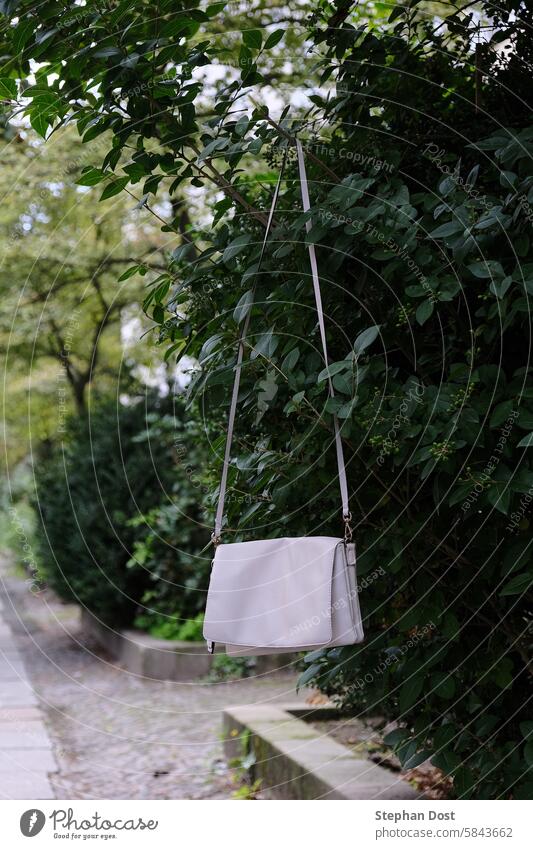 Ladies' handbag to go... Berlin Germany lady's handbag White Leather hangs Branch Bushes foliage Belt Sidewalk second hand Second-hand Dispose of Passing on